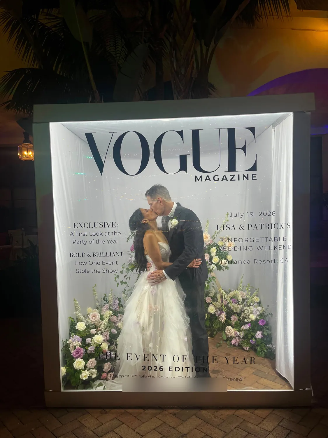 Bride and groom kissing inside the light-up Magazine Box with flowers