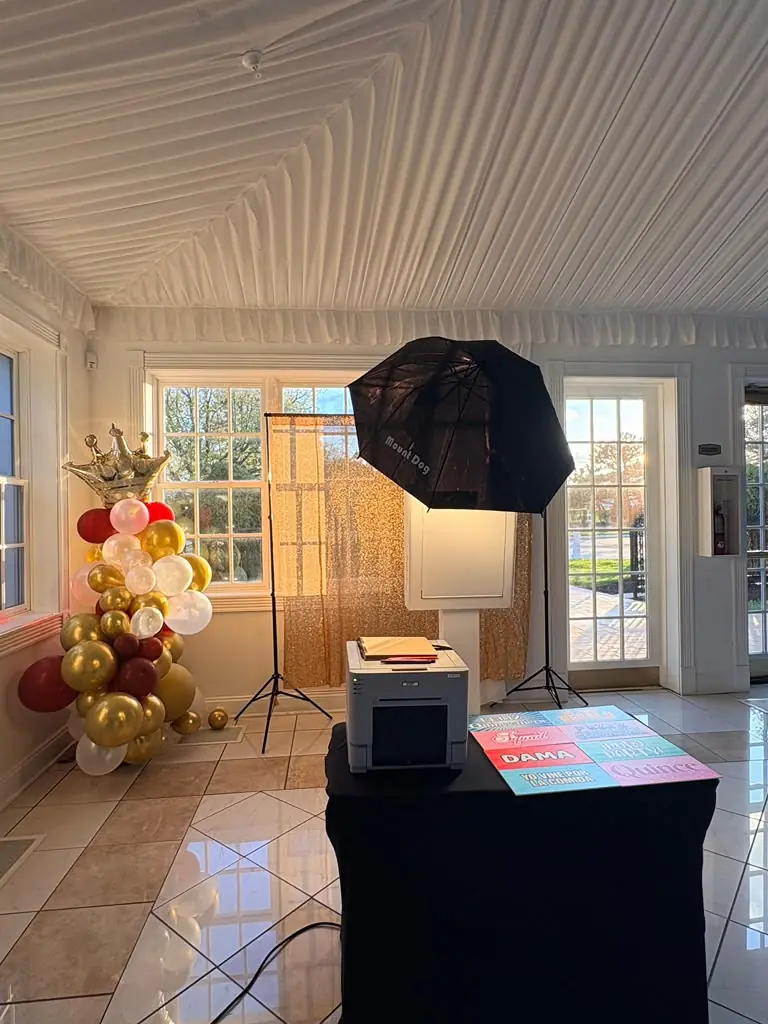 Booth with gold backdrop and balloons